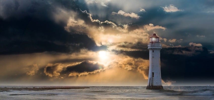Sun through clouds with lighthouse