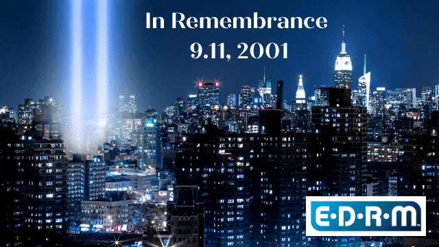 In remembrance 9.11.2001 superimposed on a night skyline of New York City, with two spotlights reaching to the sky at the memorial site.  EDRM