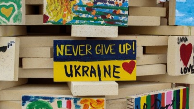 Signs, with one in the center:  Never give up!  Ukraine, with a heart.