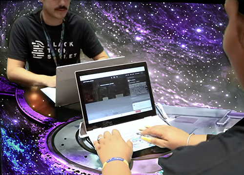 Two hackers in space typing on laptops